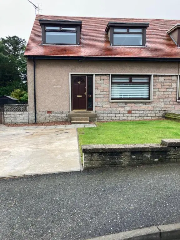 a brick house with a driveway and a door at No 22 in Banff