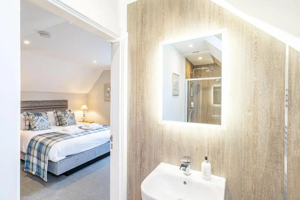 a bathroom with a bed and a sink and a mirror at Monarch Lodge 14 with Hot Tub in Belladrum