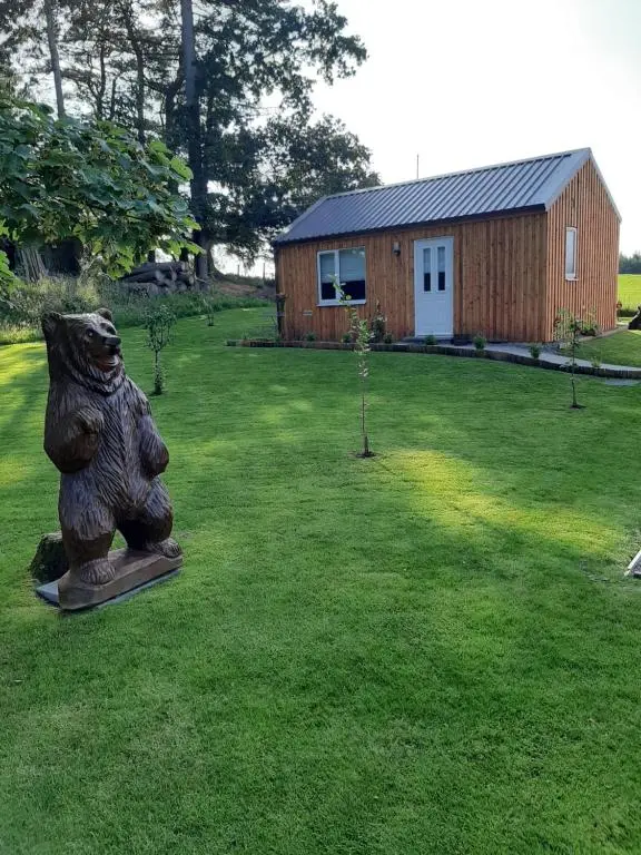 a statue of a bear in a yard with a building at Beautiful studio chalet in the Highlands in Inverness
