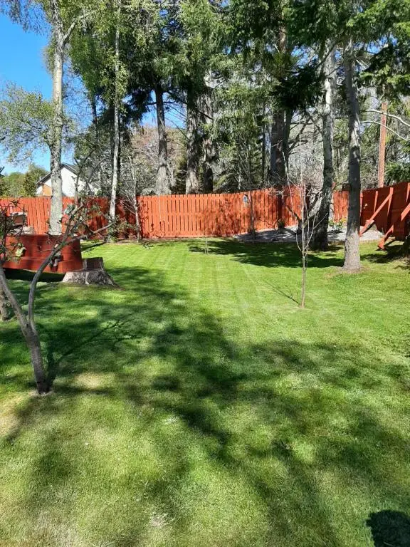 a yard with an orange fence and green grass at Beautiful studio chalet in the Highlands in Inverness