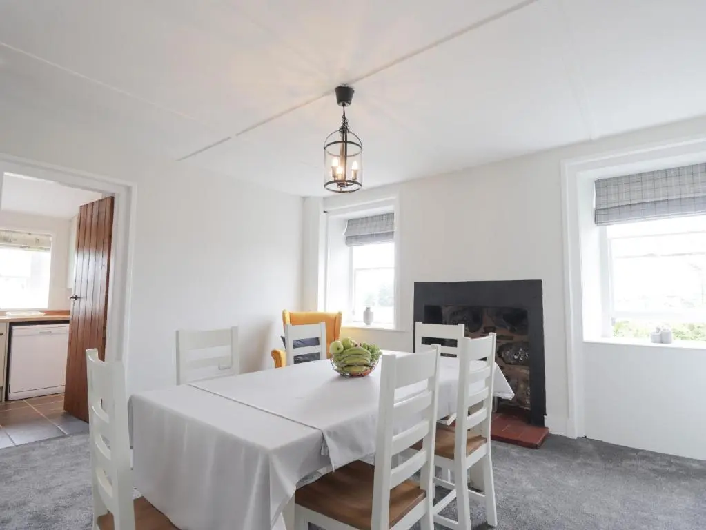 a white dining room with a white table and chairs at Garden House - Brodie Castle in Forres