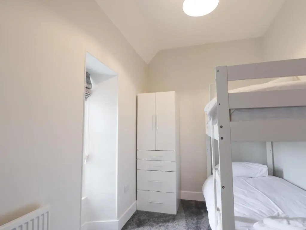 a bedroom with a bunk bed and a mirror at Garden House - Brodie Castle in Forres