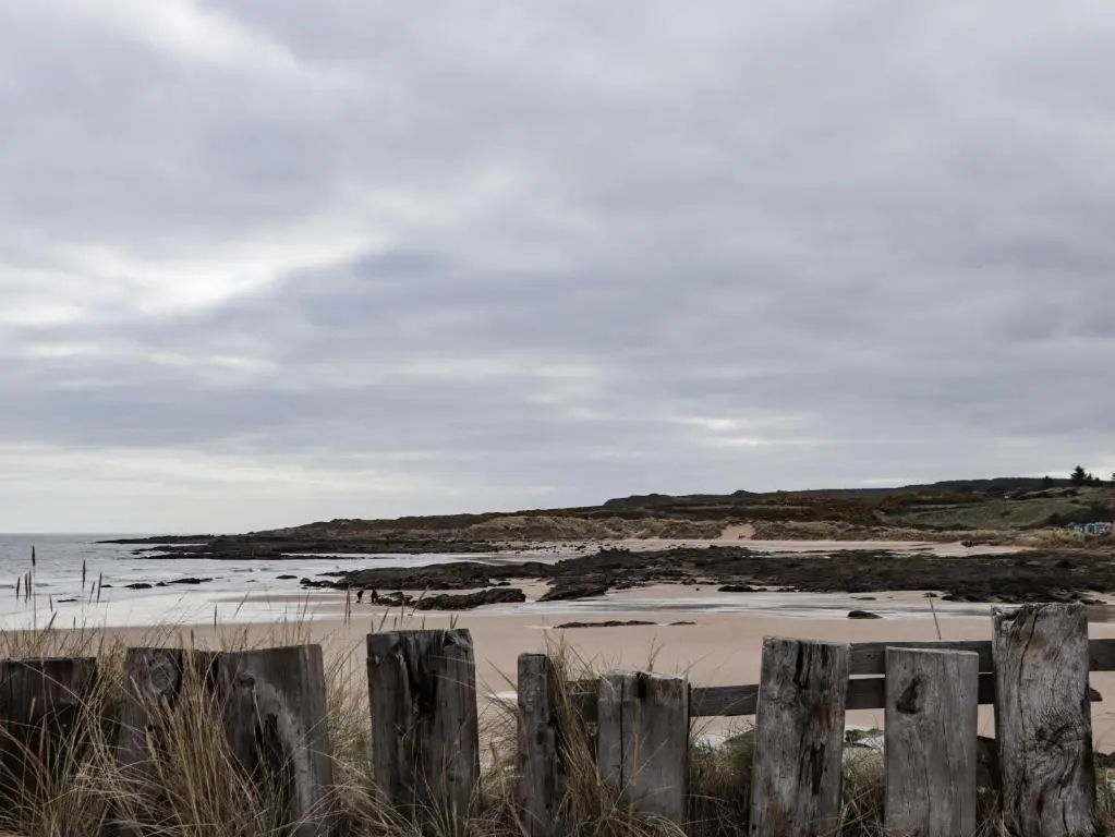 a view of a beach with a wooden fence at Seaview at The Doocot in Elgin