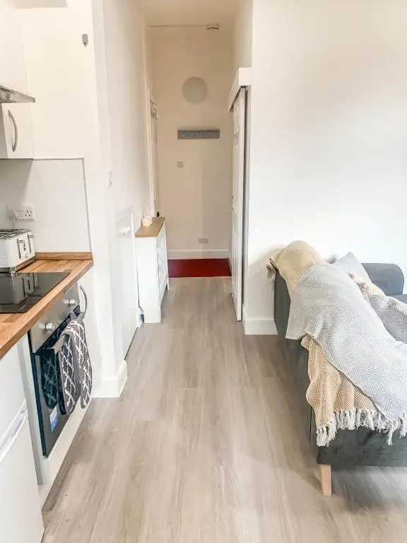 a living room with a couch and a kitchen at The Rosebery Retreat By The Castle 1-Bed Apartment in Inverness