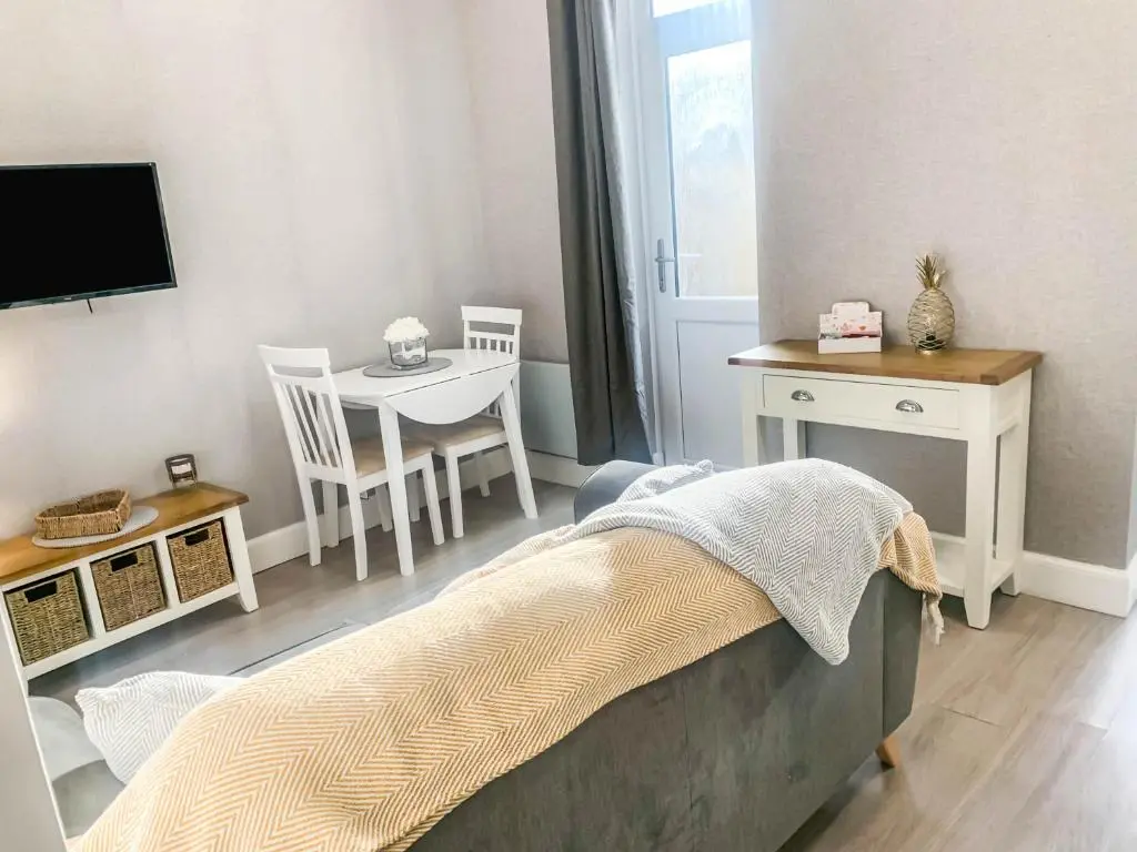 a bedroom with a bed and a table and a tv at The Rosebery Retreat By The Castle 1-Bed Apartment in Inverness