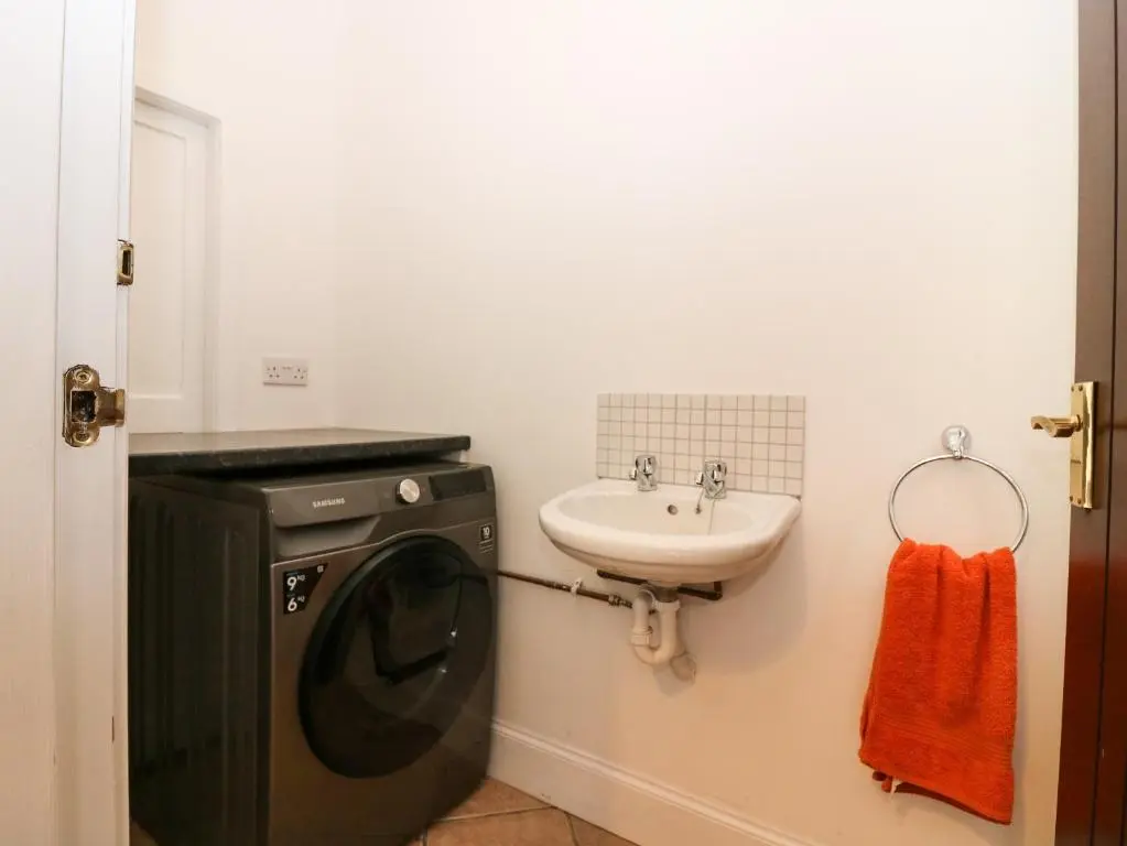 a bathroom with a washing machine and a sink at Hayloft in Peterhead