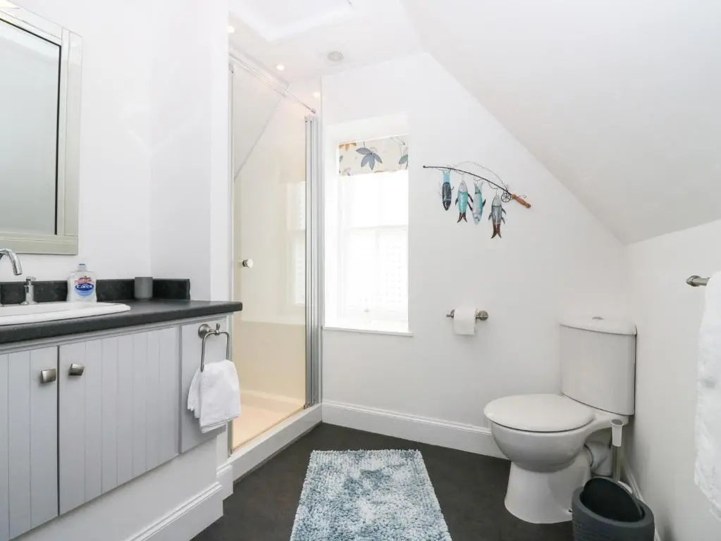 a white bathroom with a toilet and a sink at Hayloft in Peterhead