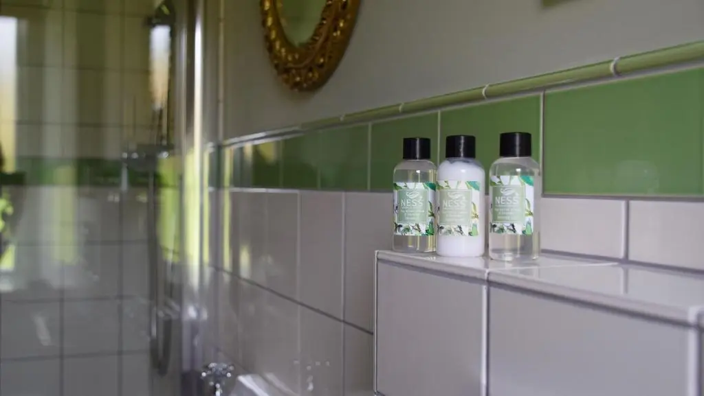 a bathroom with four bottles on a counter in a room at Saplinbrae Hotel and Lodges in Mintlaw