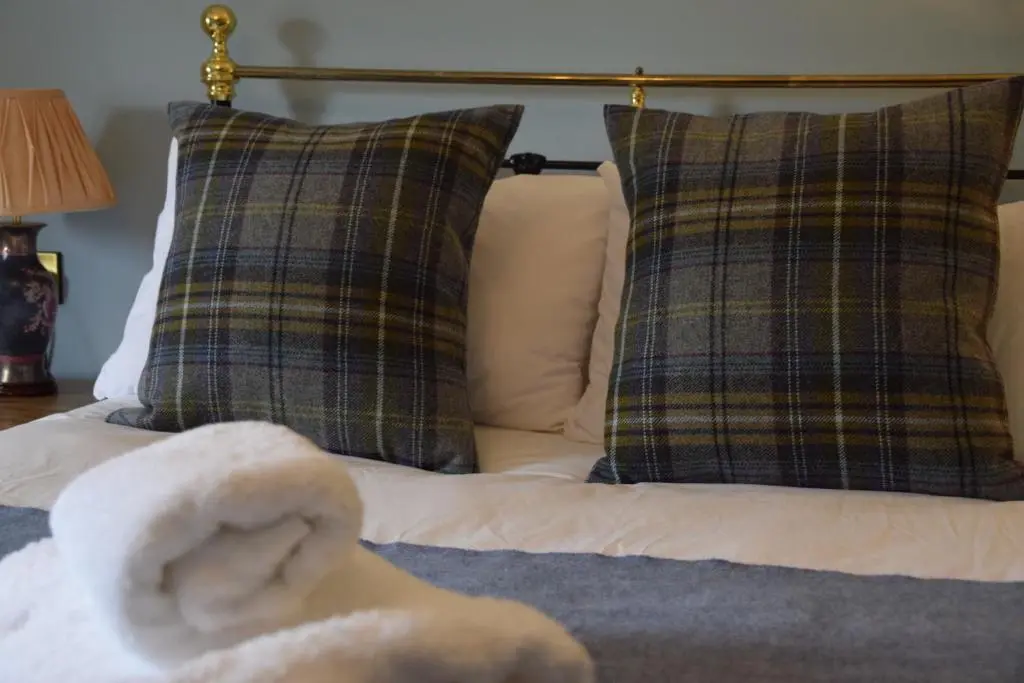 a stuffed animal on a bed with two pillows at Saplinbrae Hotel and Lodges in Mintlaw
