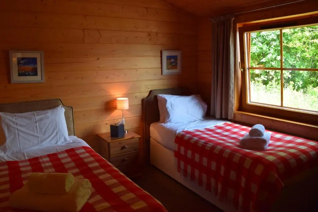 a bedroom with two beds with a teddy bear sitting on the bed at Saplinbrae Hotel and Lodges in Mintlaw