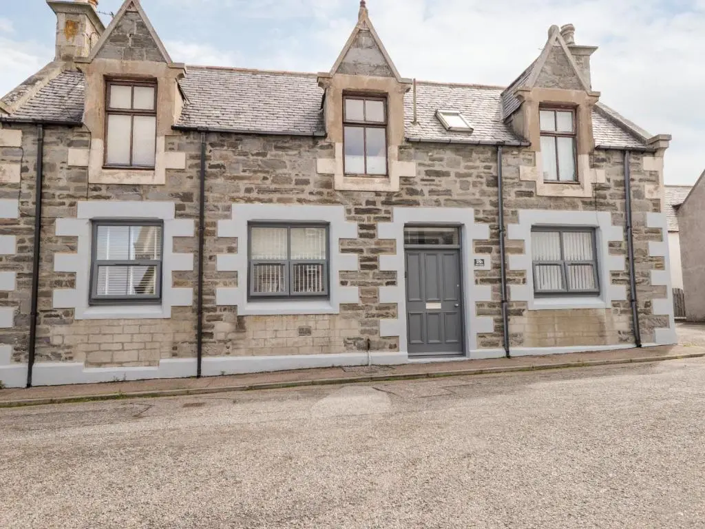 an old stone house on the side of a street at 18b New Street in Buckie