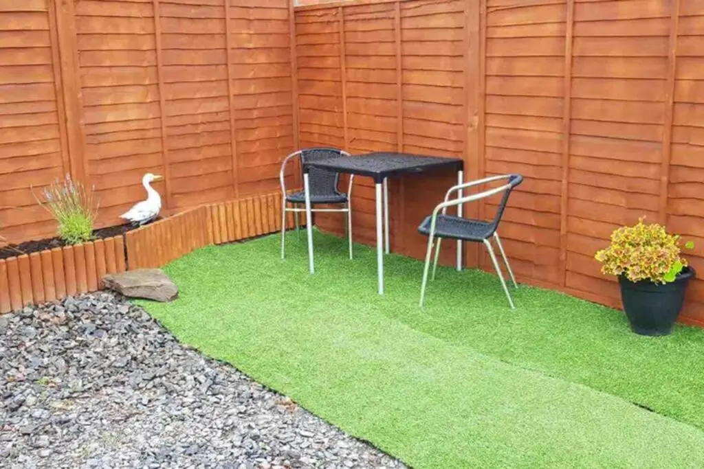 a bird sitting on the grass next to a table and chairs at Unique luxury cabin in Inverness