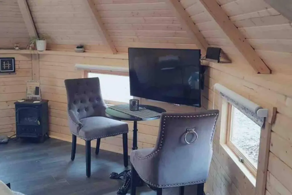 a desk with a computer and two chairs in a room at Unique luxury cabin in Inverness