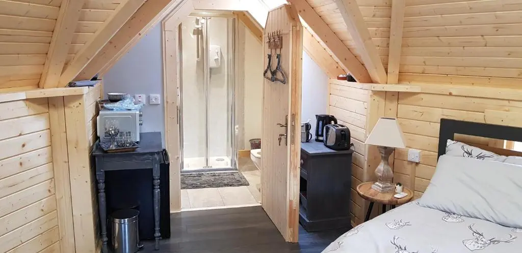 a bedroom with a bed in a wooden cabin at Unique luxury cabin 2 in Inverness