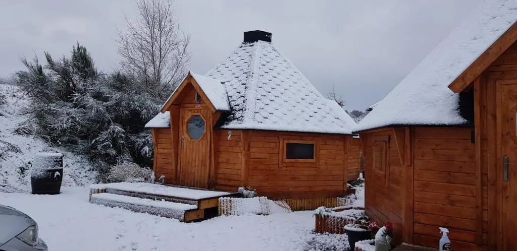 a wooden cabin with snow on the roof at Unique luxury cabin 2 in Inverness