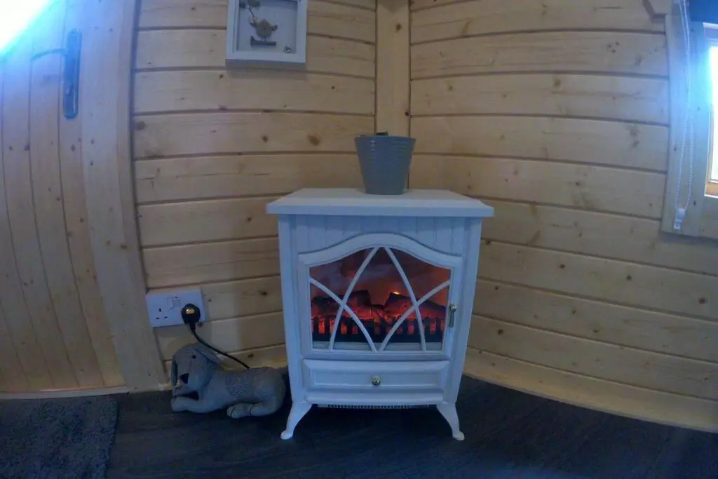 a blue stove in a room with a wall at Unique luxury cabin 2 in Inverness