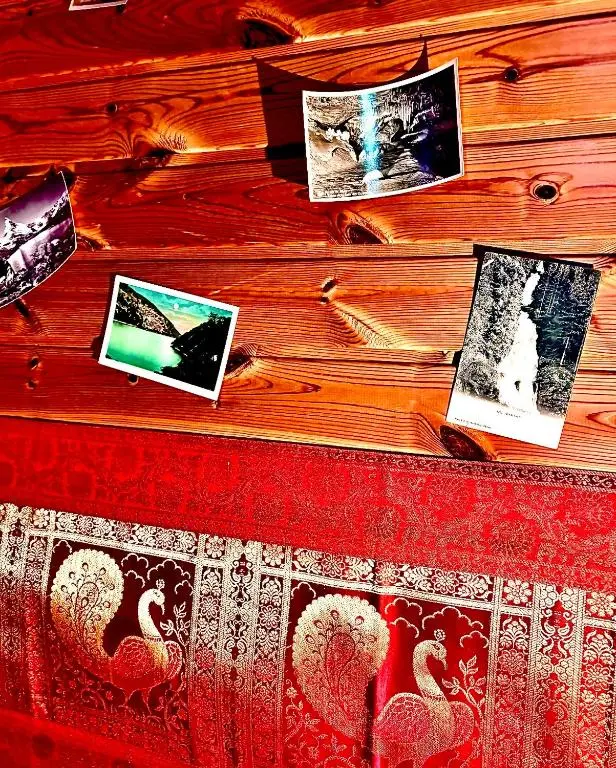 a bed with pictures on a wooden wall at Braemar Lodge Cabins Not for profit in Braemar