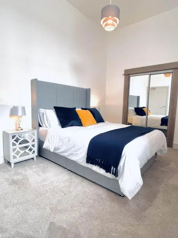 a bedroom with a large bed and a mirror at No 49 a spacious executive apartment in Inverness in Inverness
