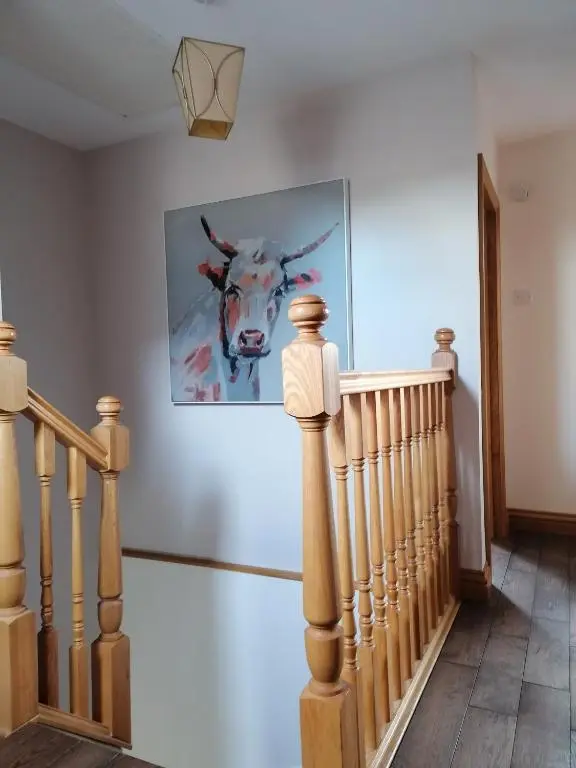 a painting of a cow on a wall next to a staircase at Sunnyside House in Gardenstown