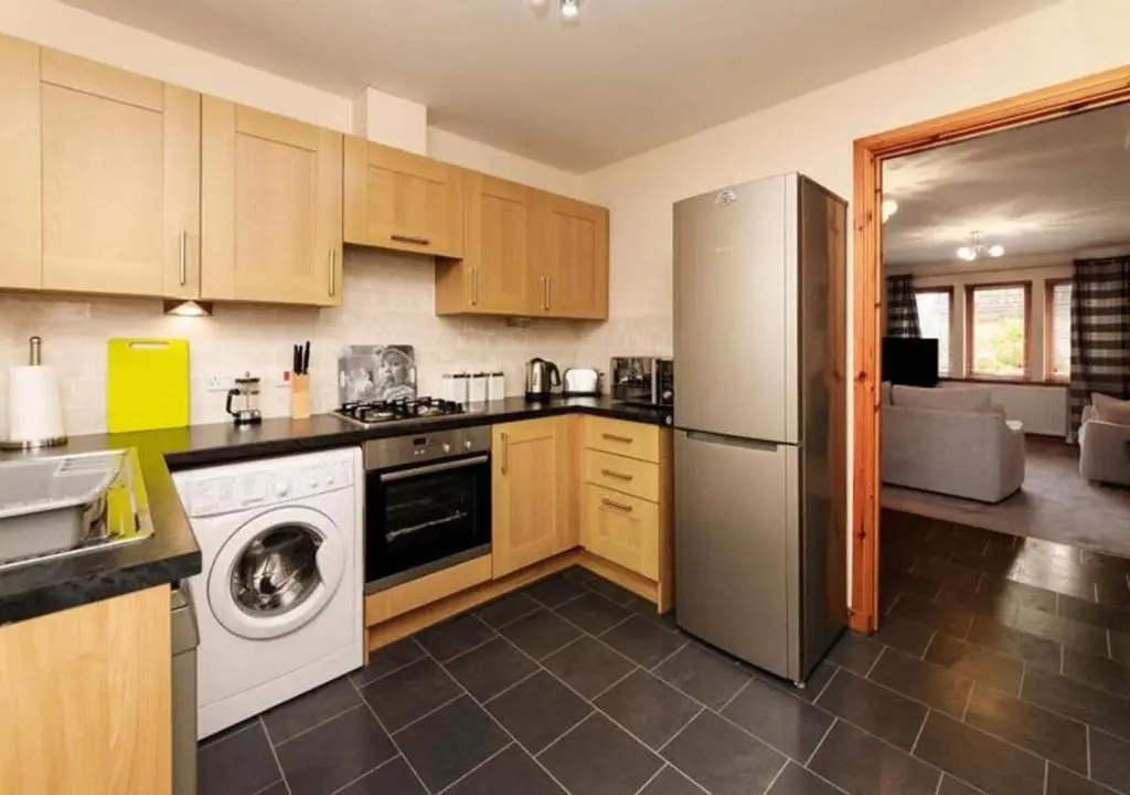 a kitchen with a refrigerator and a dishwasher at Modern 2 Bedroom Semi detached House with own private driveway in Inverness