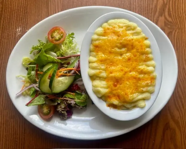 a white plate with a plate of food and a salad at The Ferry Boat Inn in Ullapool