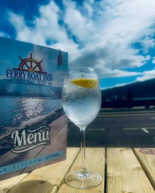 a wine glass sitting on a table next to a box at The Ferry Boat Inn in Ullapool