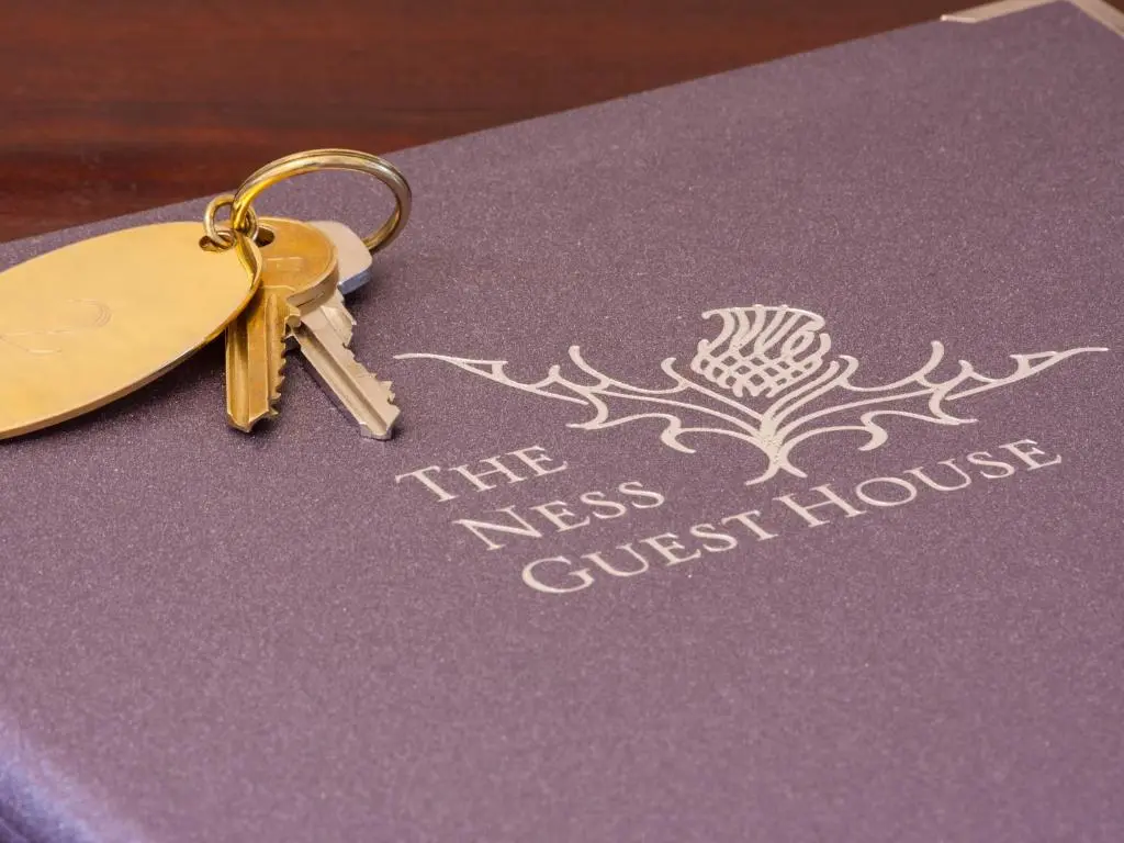 a pair of keys sitting on top of a passport at The Ness Guest House in Inverness
