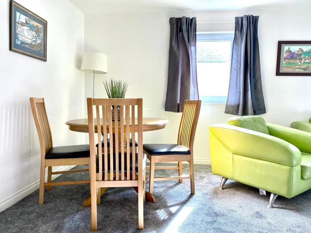 a living room with a table and chairs and a couch at Modern Spacious, Near Marina - Commerce Street, Lossiemouth - Free Parking, WiFi in Lossiemouth