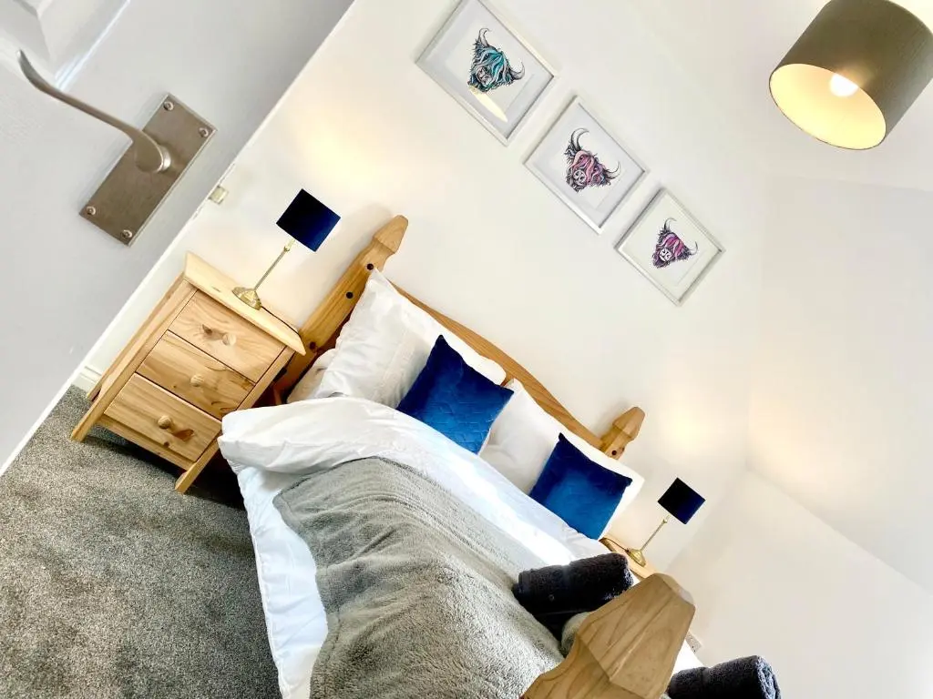 a bedroom with a bed with blue pillows at Modern Spacious, Near Marina - Commerce Street, Lossiemouth - Free Parking, WiFi in Lossiemouth