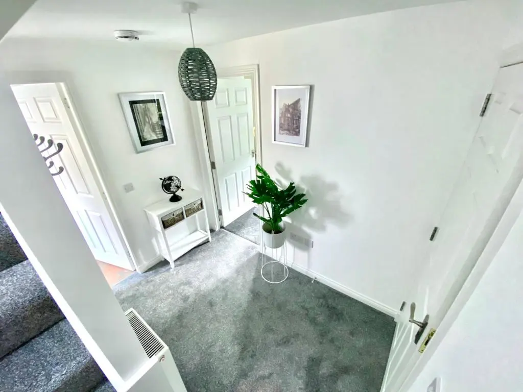 an empty hallway with white walls and a potted plant at Modern Spacious, Near Marina - Commerce Street, Lossiemouth - Free Parking, WiFi in Lossiemouth