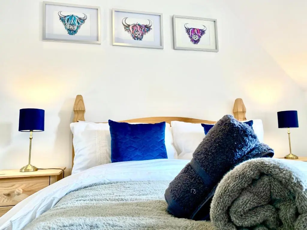 a bedroom with a bed with blue pillows at Modern Spacious, Near Marina - Commerce Street, Lossiemouth - Free Parking, WiFi in Lossiemouth