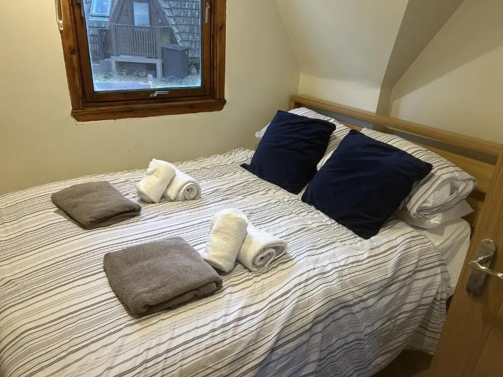 a large bed with towels and pillows on it at Bright Star Lodge in Spean Bridge