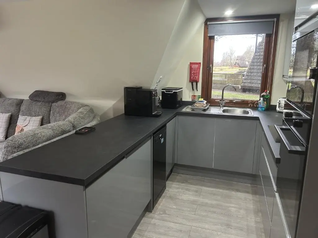a kitchen with a counter and a sink and a couch at Bright Star Lodge in Spean Bridge