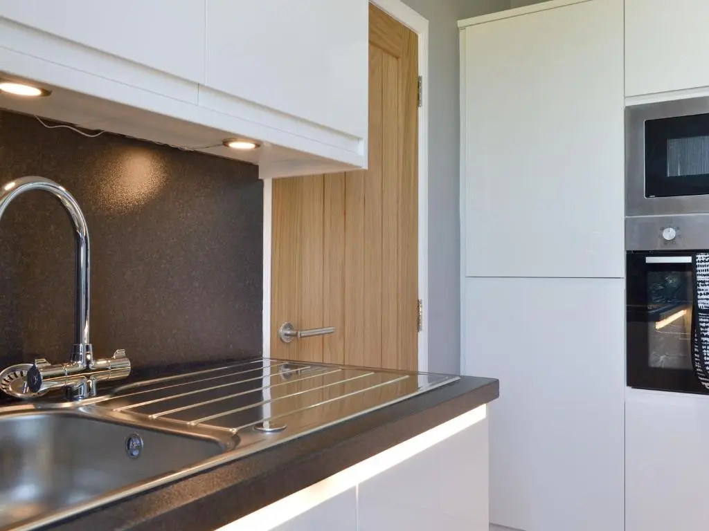 a kitchen with a sink and a microwave at Inver House Apartment in Inverurie