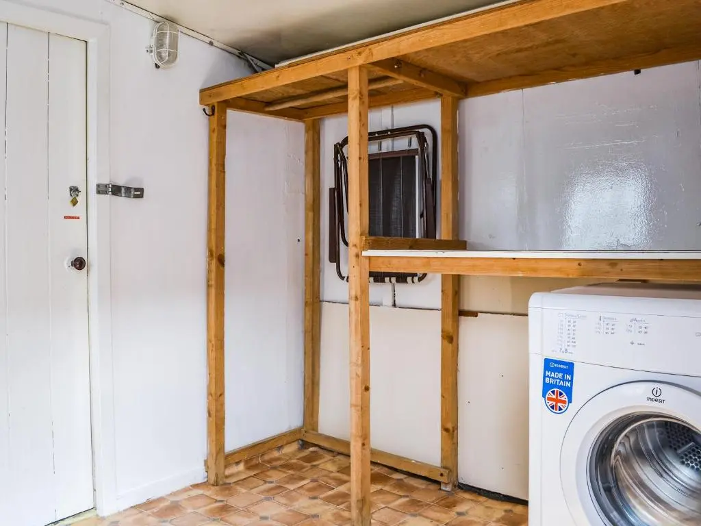 a laundry room with a washer and dryer at Needle Cottage in Cullen