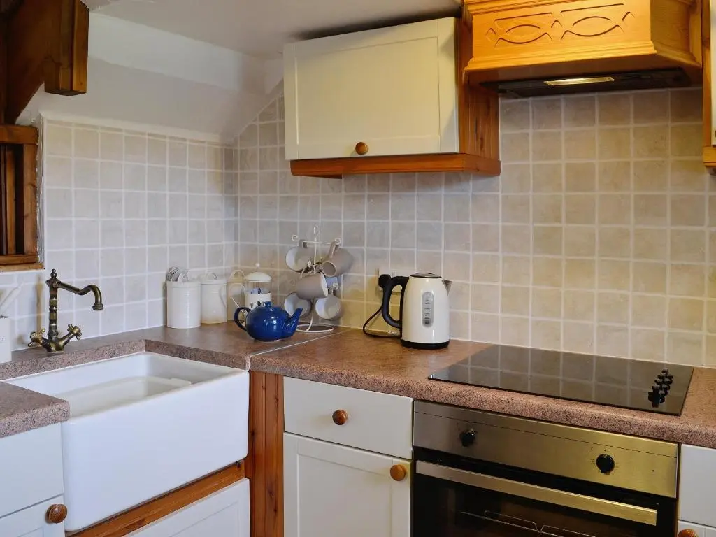 a kitchen with a sink and a counter top at Woodside Cottage in Auchnastank