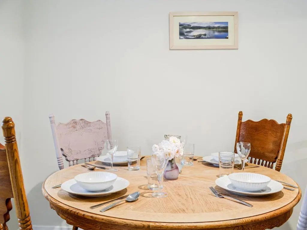 a wooden table with plates and dishes on it at Corrennie School Cottage in Whitehouse