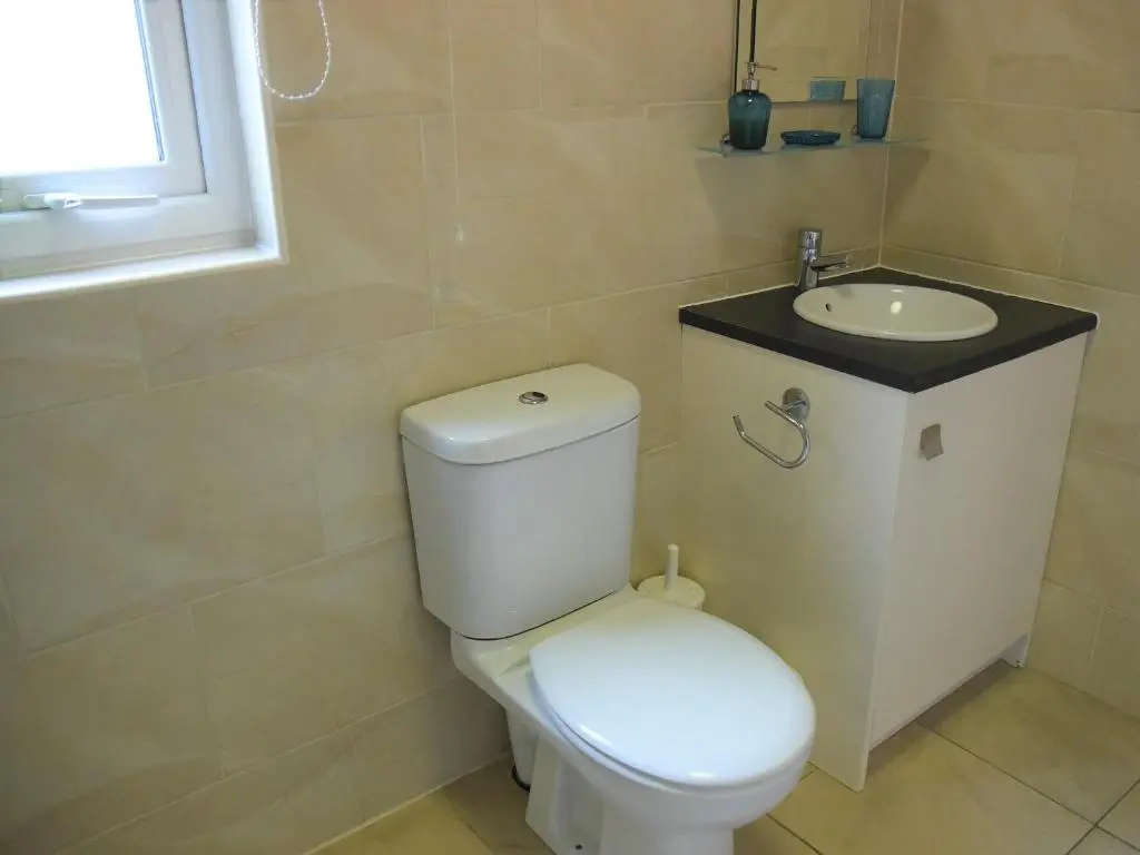 a bathroom with a white toilet and a sink at Bonnie Doon in Aviemore