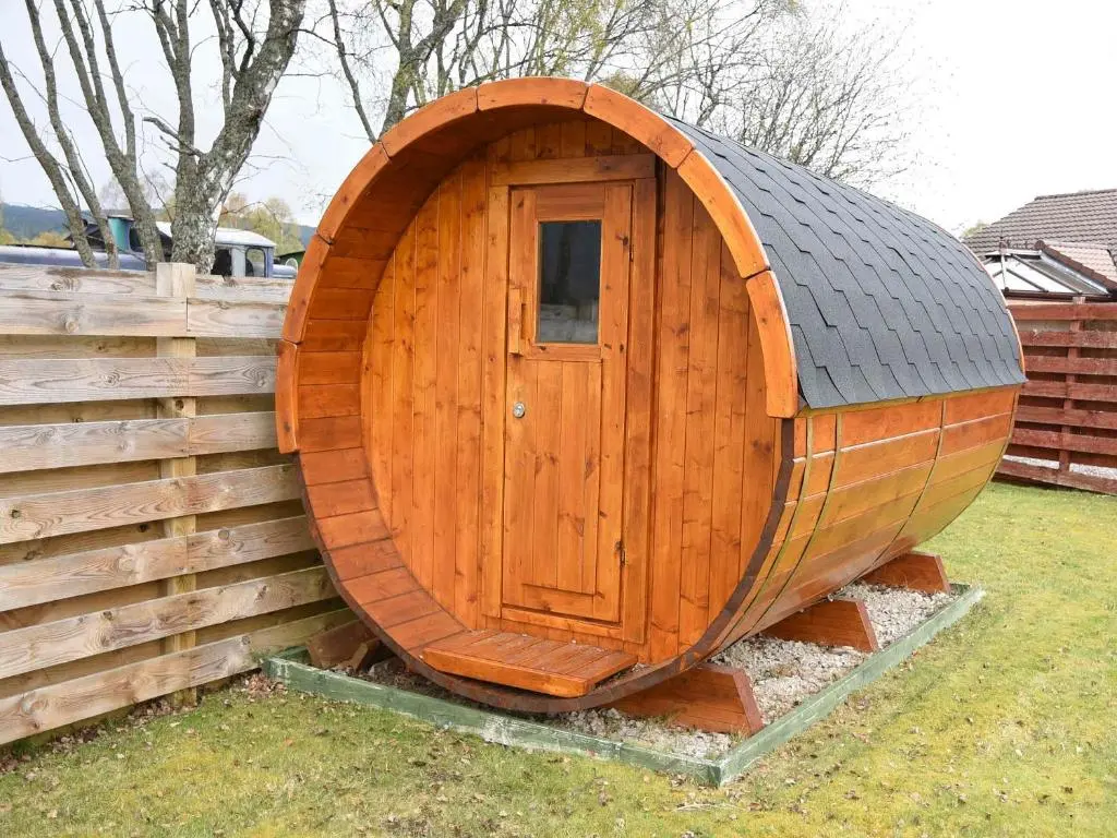 a wooden hobbit house with a door in a yard at Bonnie Doon in Aviemore