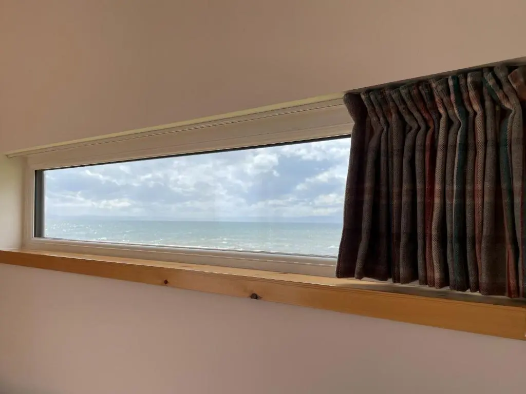 a window with a view of the ocean at Sunrise Summerhouse in Hilton of Cadboll