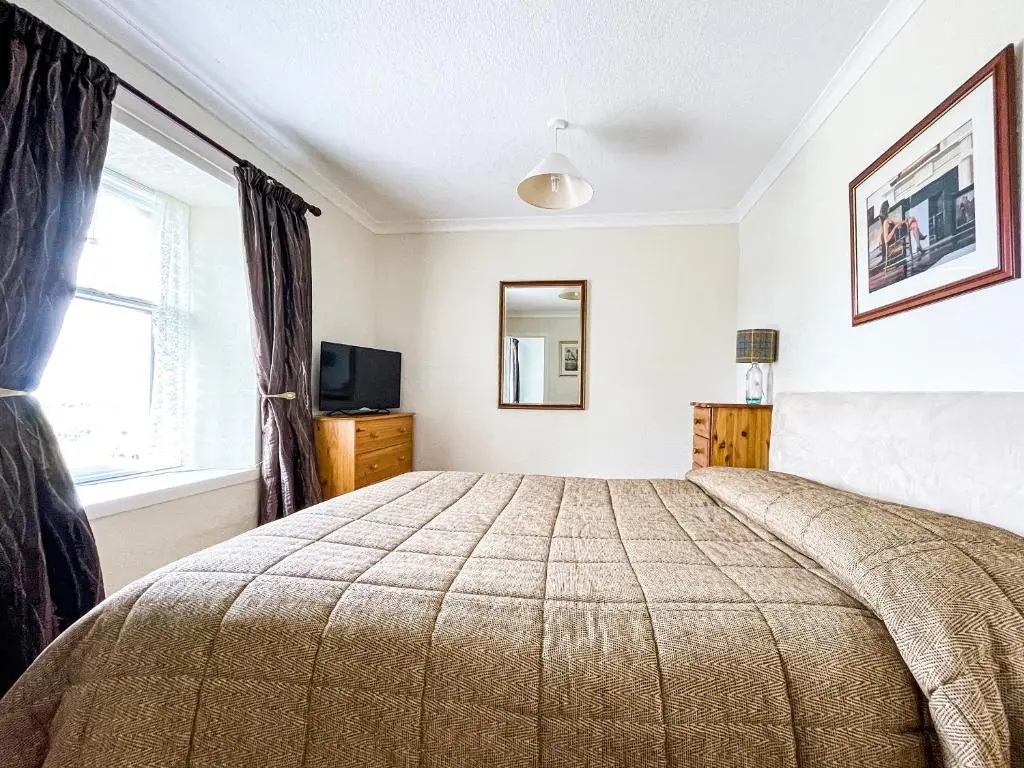 a bedroom with a bed and a window at Fourpenny Cottage - Uk34744 in Embo