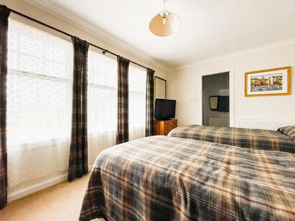 a bedroom with two beds and a large window at Fourpenny Cottage - Uk34744 in Embo