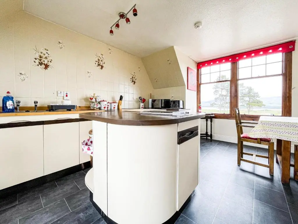 a kitchen with white cabinets and a counter top at Fourpenny Cottage - Uk34744 in Embo
