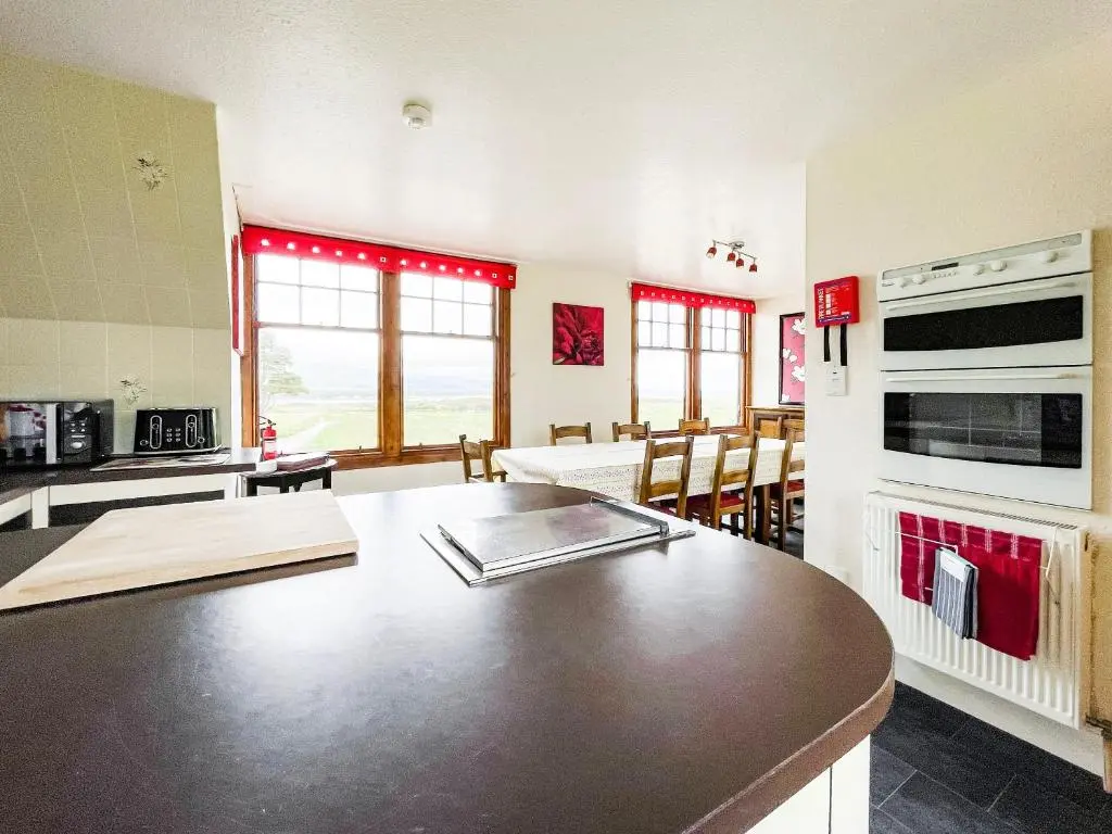 a kitchen with a counter top and a table in a room at Fourpenny Cottage - Uk34744 in Embo