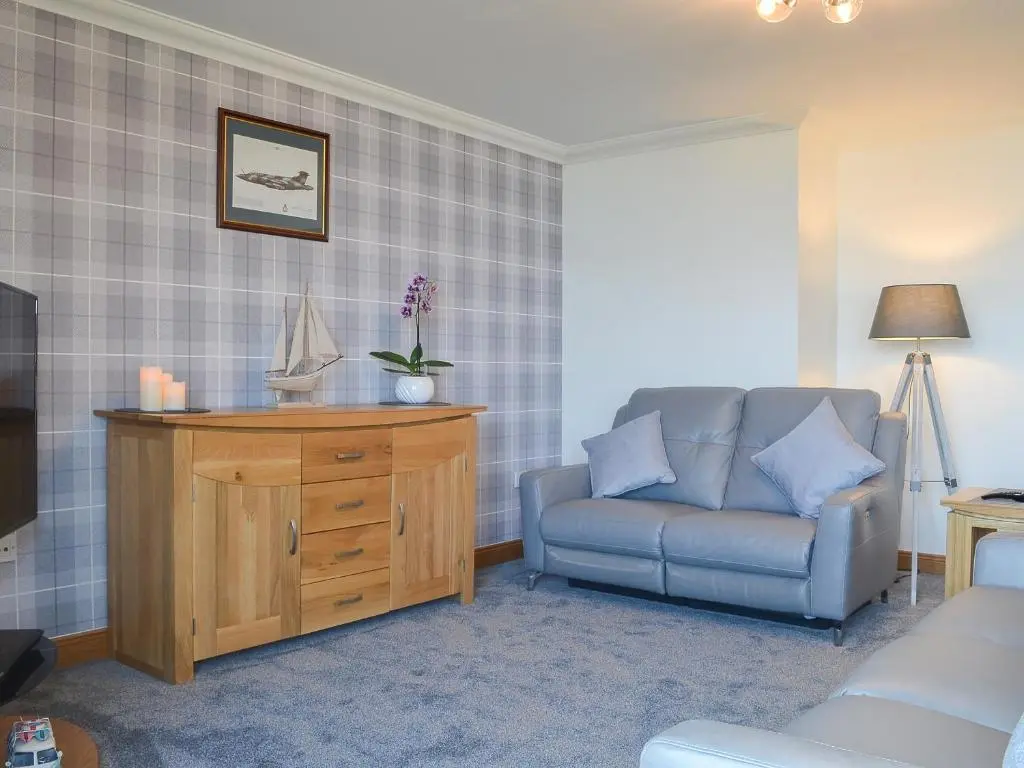 a living room with a couch and a chair at Aurora in Lossiemouth
