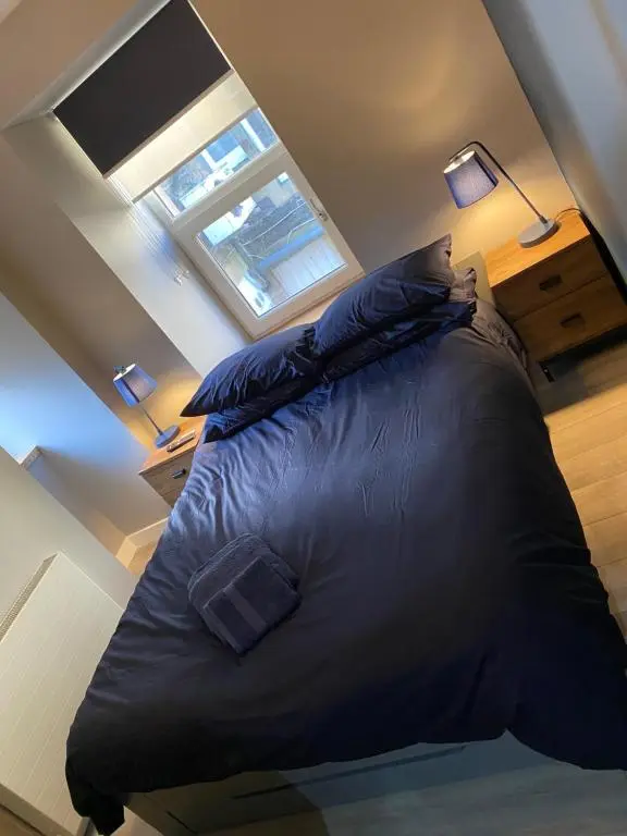 a large bed in a room with two lamps at Town centre 3 bed luxury apartment in Wick