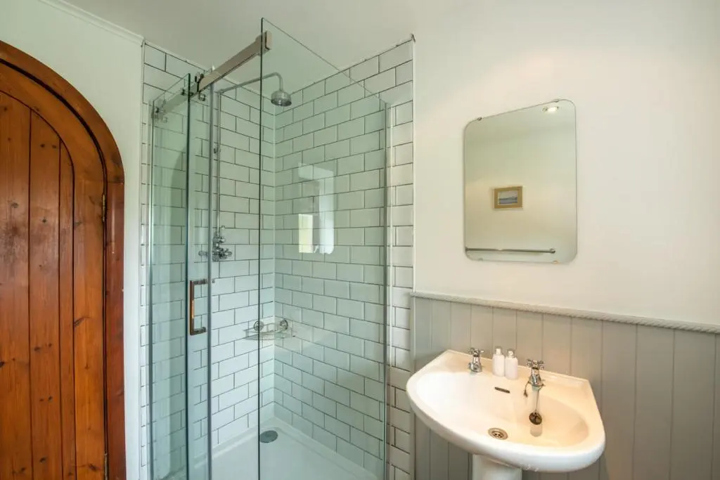 a bathroom with a sink and a glass shower at Beautiful Character House in Muir of Ord in Muir of Ord