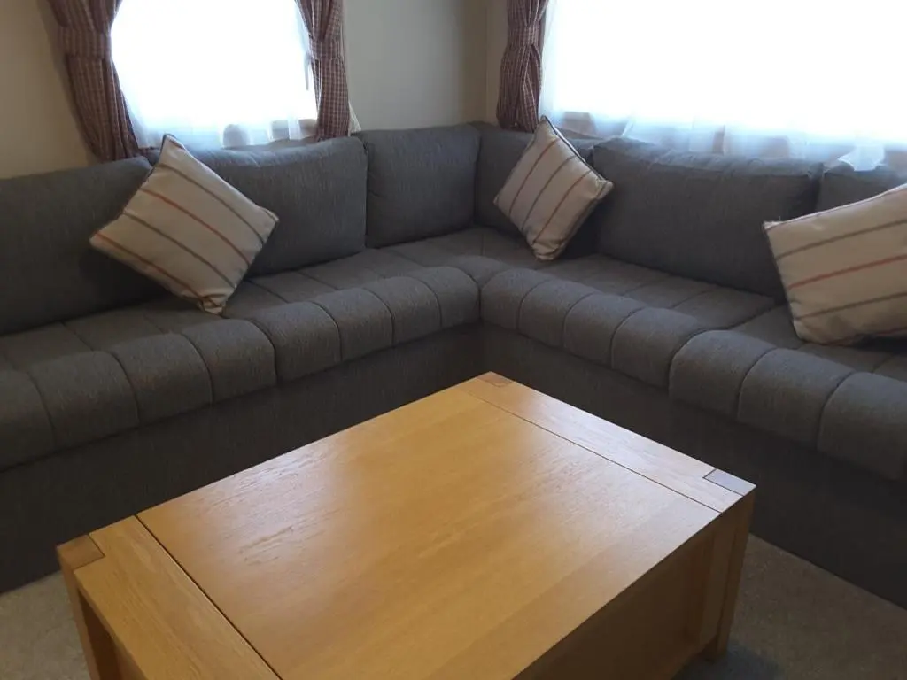 a living room with a couch with a wooden coffee table at No 46 Coorie-in in Boat of Garten