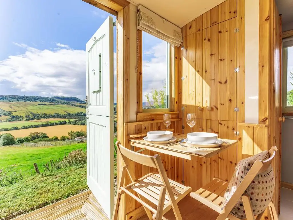 a dining room with a table and chairs and a window at Woodside Hut 3 - Uk36107 in Auchterneed
