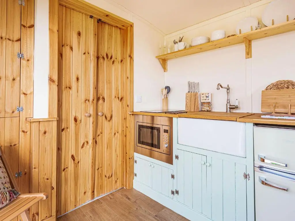 a kitchen with wood paneling and a counter top at Woodside Hut 3 - Uk36107 in Auchterneed